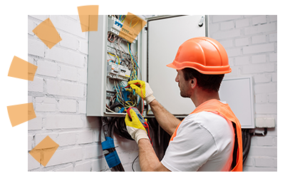 An electrician performs work at a breaker box.