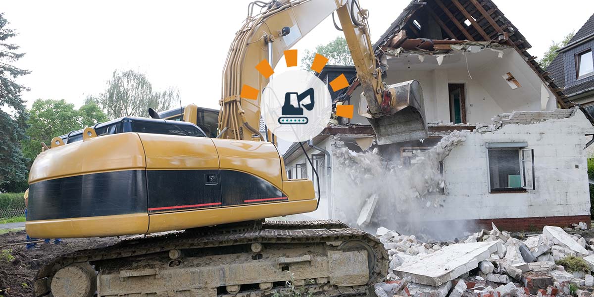 Hydraulic excavator destroys upper floor of a house.