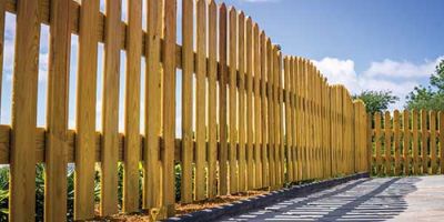 A Wooden Fence Surrounding a Concrete Patio.