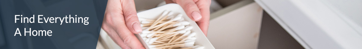 Woman organizing a grey bathroom drawer.