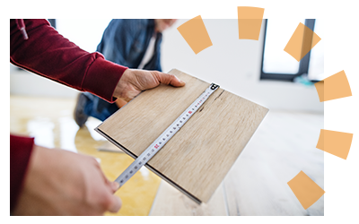 A person measuring a plank of vinyl flooring. 