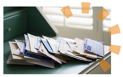 A pile of letters and mail sitting on a green desk. 
