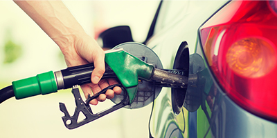 A person fueling a gar with gasoline. 