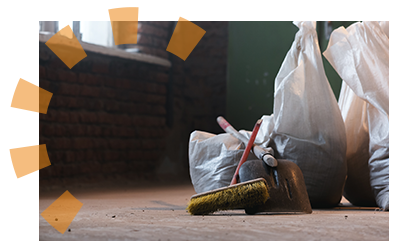 A broom and trash bags inside of a barn
