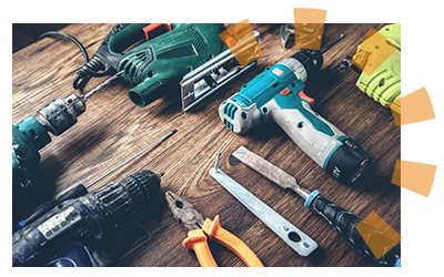 Electric drill, saw, pliers, chisel, tools on a wood table. 