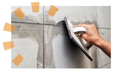 A person grouting their new bathroom tile.