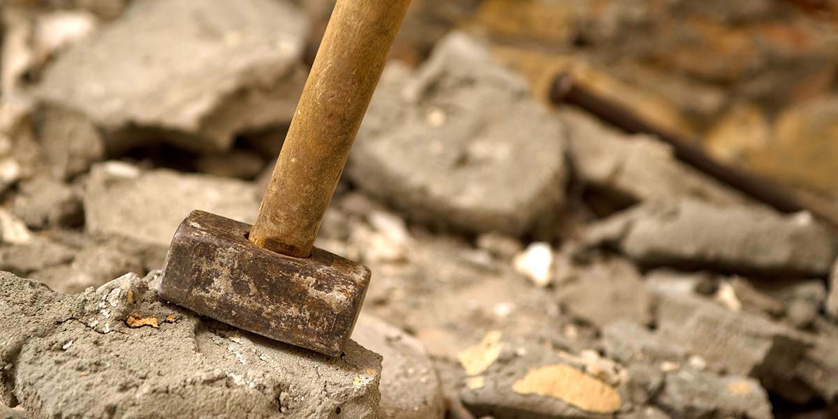 Sledgehammer Resting on Broken Sections of Concrete.