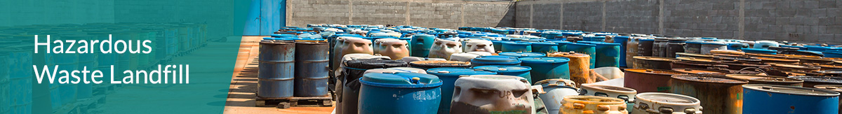 Barrels full of toxic material lined up and sorted on wood pallets at a hazardous waste facility.