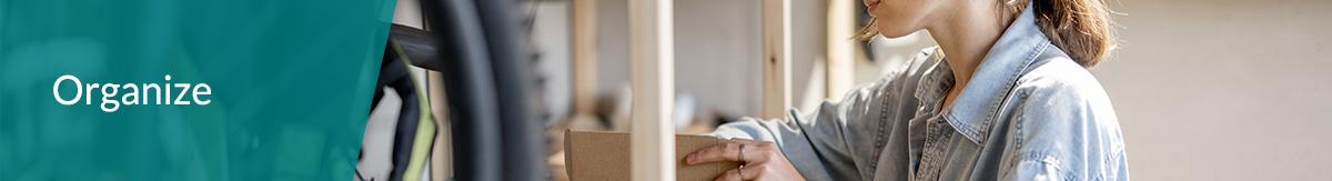 White text 'Organize' over image of a homeowner organizing items in home to prep for sale.