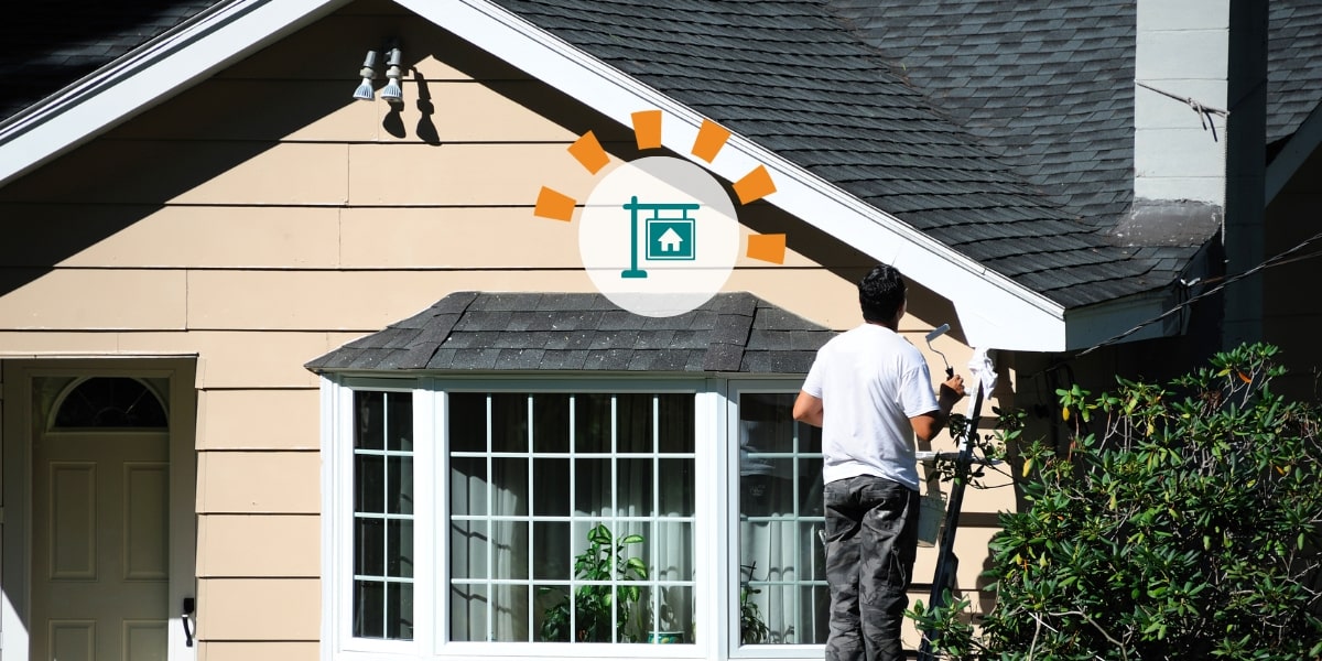 Homeowner prepping house for sale painting exterior.