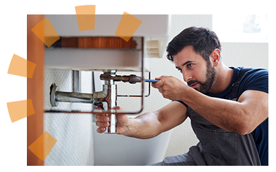 Bearded man homeowner uninstalling bathroom sink plumbing for remodel.