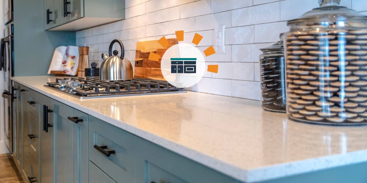 A shiny white countertop with a tea kettle in the background.