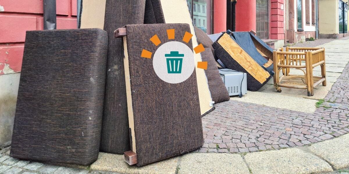 An assortment of couches and other bulky debris on a street corner.