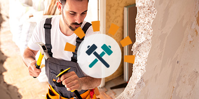 Person knocking down a wall for an open concept living room.