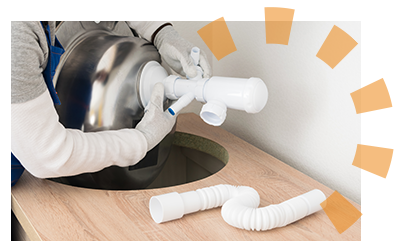 A plumber installs a sink after countertop installation.