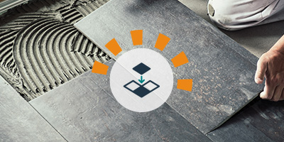 Homeowner installing tile floor in bathroom. 