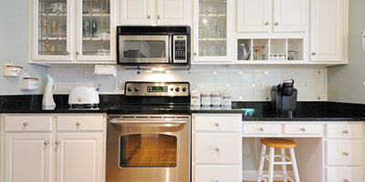 Black laminate kitchen countertops on top of white cabinets.