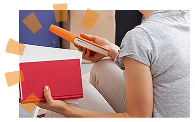 A woman holding red white and orange books to donate