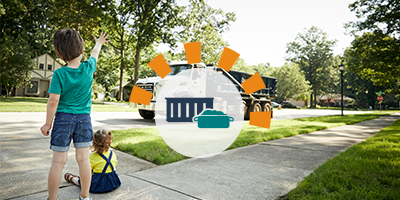 Kids waving at a Dumpsters.com dumpster truck