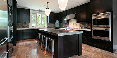 A modern kitchen with black cabinets and stainless steel countertops. 