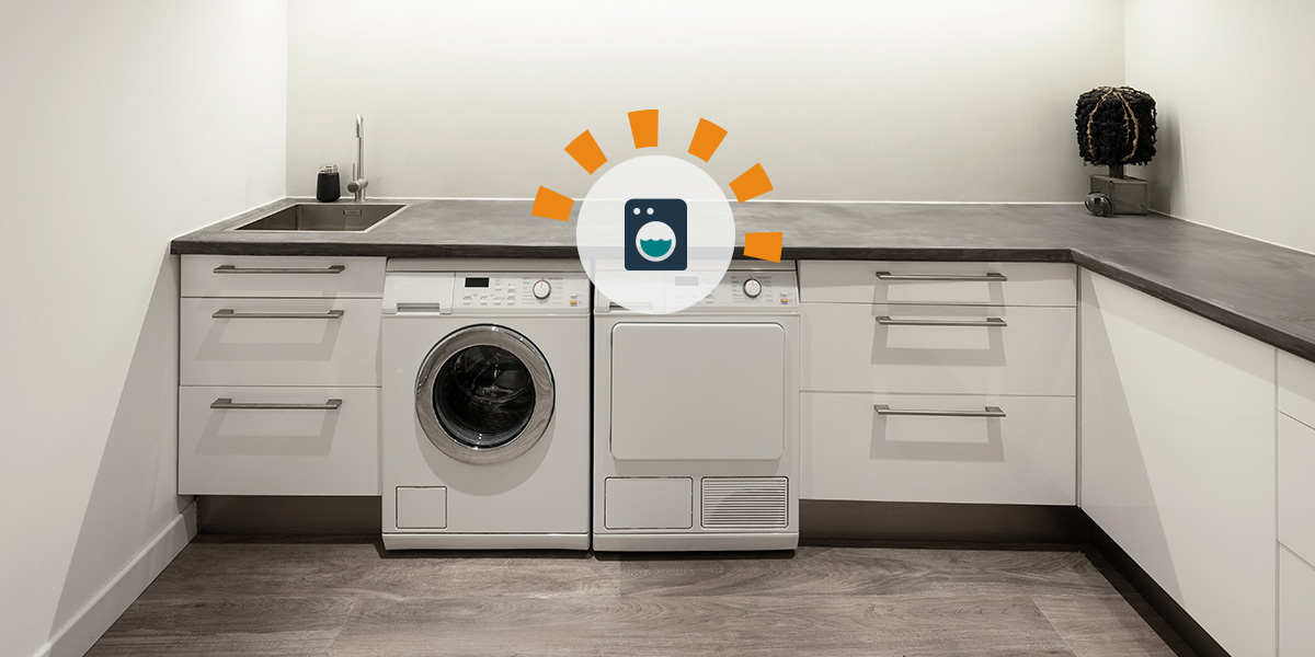 Renovated laundry room with grey cabinets and washer and dryer. 