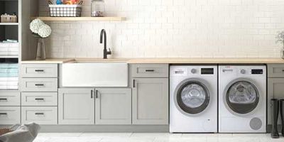 Laundry Room With White Appliances and Gray Cabinets.