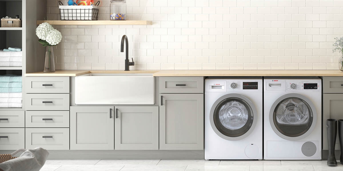 Laundry Room With White Appliances and Gray Cabinets.