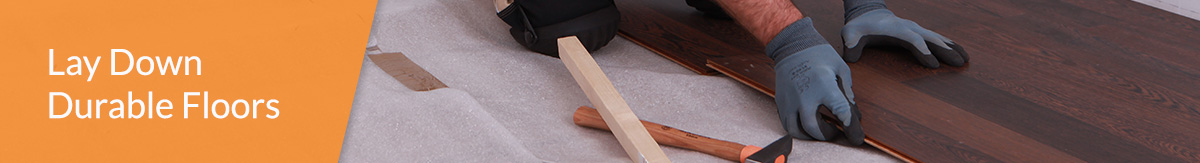 Homeowner laying down durable laminate flooring.