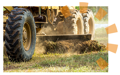 A motor grader clearing and leveling land. 