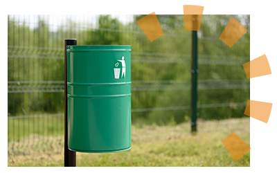 A green trash can on a black pole.