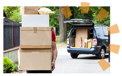 A man in a red shirt taking boxes to his blue car 