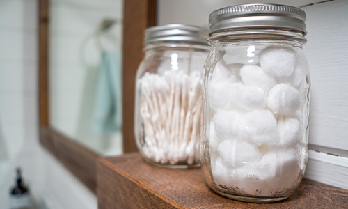 Mason jars filled with bathroom toiletries for storage.