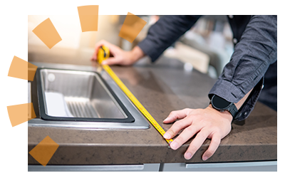 A worker measures a countertop prior to removal.