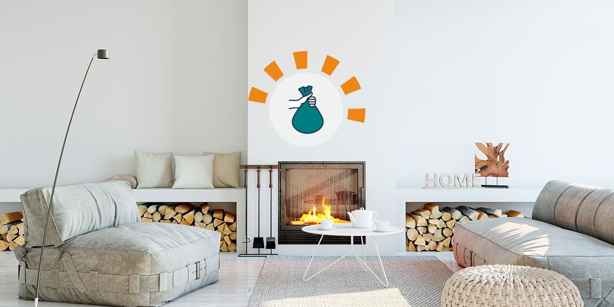 A white living room with a fireplace and firewood grey couches and a white coffee table.