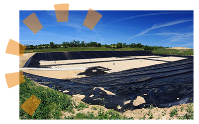 Modern sanitary landfill with layers surrounded by green grass and blue sky.