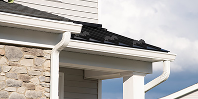 New gutters installed over the front edge of a house. 