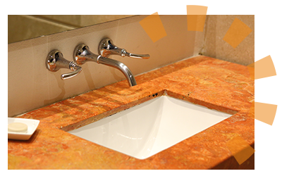 A bathroom sink with orange countertop.