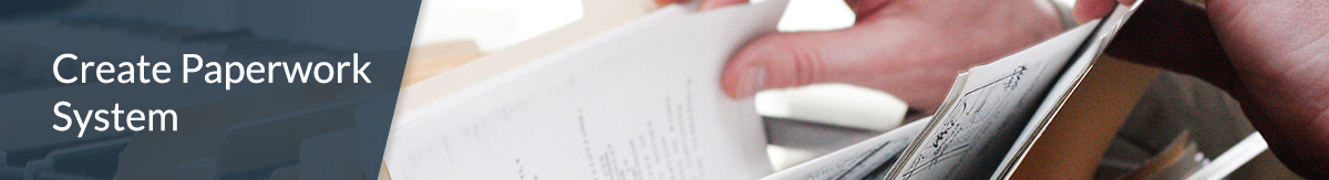 An open file cabinet drawer with a person leafing through files.