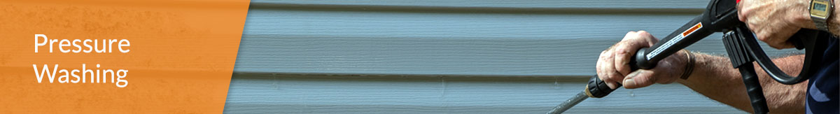 Image of a person power washing grime off the side of a house.