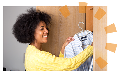 A woman putting clothing back into her closet.