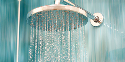 Closeup view of a newly installed rainfall showerhead after an old shower tearout.