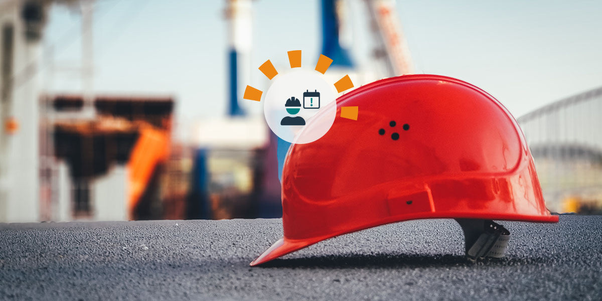 A red construction hard hat on the ground on a construction site.
