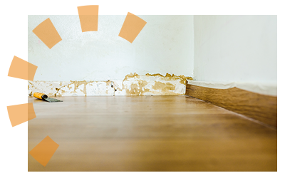 View of wood floor with baseboards removed from the painted drywall.