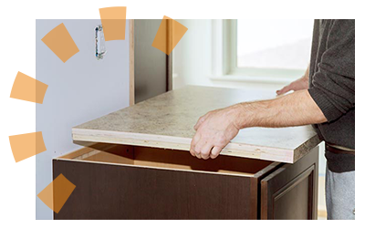 A man removing white laminate countertop from cabinet base. 