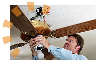 A man removes a ceiling fan.