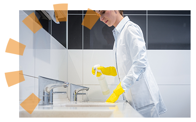 A janitor cleans the sinks of a bathroom.