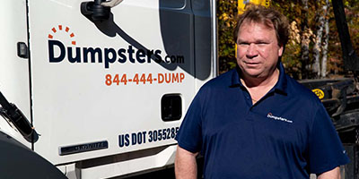 COO of Dumpsters.com's Cleveland Hauling Operations Rich Gersdorf Standing Next to a Dumpsters.com Truck.