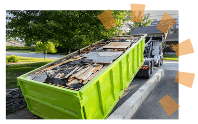 Roll off dumpster truck dropping off a green dumpster.
