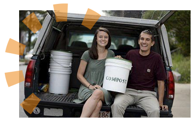 Owners of Roots Compost sitting in truck bed holding a compost pail.