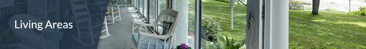The header "landscaping" over the photo of a screened in porch with white wicker rocking chairs and tables overlooking backyard with lake view.